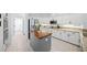 Bright kitchen featuring white cabinets, granite countertops, stainless steel appliances, and a butcher block island at 772 Live Oak Ne Ter, St Petersburg, FL 33703
