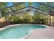 Inviting screened pool with lush landscaping and tile decking, ideal for relaxing or entertaining at 772 Live Oak Ne Ter, St Petersburg, FL 33703