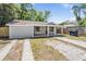 Neat single-story home features a covered porch and well-maintained front yard with a paved driveway at 805 E Elm St, Tampa, FL 33604