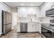 Updated kitchen with white cabinets, quartz countertops, and stainless steel appliances at 805 E Elm St, Tampa, FL 33604