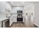 Bright kitchen featuring stainless steel appliances, white cabinets, and wood-look tile flooring at 805 E Elm St, Tampa, FL 33604