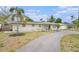 Charming single-story home featuring a circular driveway and a well-maintained front yard with a mature palm tree at 831 72Nd N Ave, St Petersburg, FL 33702