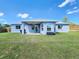 Home's backyard with covered patio, grill, and large grassy space at 8442 Pinewood Ave, Brooksville, FL 34613