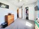 Cozy bedroom featuring a four-drawer dresser, storage closet, and an open doorway at 8442 Pinewood Ave, Brooksville, FL 34613