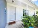 Inviting front entrance with white door, tidy landscaping, and covered porch at 8442 Pinewood Ave, Brooksville, FL 34613