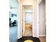 Hallway view shows a bathroom with decorative shower curtain and tile flooring and a bedroom with gray carpet at 8442 Pinewood Ave, Brooksville, FL 34613
