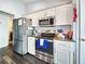 Modern kitchen with stainless steel appliances, granite countertops, and white cabinetry at 8442 Pinewood Ave, Brooksville, FL 34613