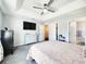 This main bedroom is complete with a ceiling fan, a television, and ensuite bath at 8442 Pinewood Ave, Brooksville, FL 34613