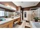 Bathroom featuring double sinks, soaking tub, tiled walk-in shower, and wood vanity at 9504 Laurel Ledge Dr, Riverview, FL 33569