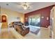Living room with wood floors, a ceiling fan, slider access to the outside, and a comfortable leather reclining sofa at 9504 Laurel Ledge Dr, Riverview, FL 33569