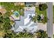 Aerial view of the home's exterior, featuring a lush yard, a pool, and a driveway at 102 Crestwood Ln, Largo, FL 33770