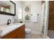 Well-lit bathroom with wood vanity, granite countertops, and stylish accents at 102 Crestwood Ln, Largo, FL 33770
