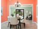 Charming dining room with orange and mint colored walls and a view into the green living space at 102 Crestwood Ln, Largo, FL 33770