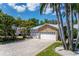 Aerial view of a single-Gathering home featuring a basketball court, stone accents, a driveway, and lush landscaping at 102 Crestwood Ln, Largo, FL 33770