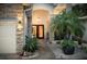 Elegant double front doors framed by stone accents and lush tropical landscaping at 102 Crestwood Ln, Largo, FL 33770