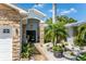 Inviting front entrance with stone columns, black double doors, and a landscaped walkway leading to the covered porch at 102 Crestwood Ln, Largo, FL 33770