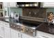 Gourmet kitchen features stainless steel appliances, a cooktop, and granite countertops with tile backsplash at 102 Crestwood Ln, Largo, FL 33770
