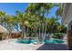 Private pool surrounded by lush palm trees and a brick patio at 102 Crestwood Ln, Largo, FL 33770