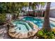 Inviting pool and hot tub surrounded by tropical foliage create a relaxing outdoor oasis at 102 Crestwood Ln, Largo, FL 33770