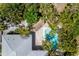 Overhead view of the kidney-shaped pool and tiki hut surrounded by lush landscaping at 102 Crestwood Ln, Largo, FL 33770