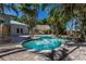 Beautiful pool area with a thatched gazebo and lush tropical landscaping, perfect for relaxation at 102 Crestwood Ln, Largo, FL 33770