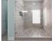 Modern walk-in shower features pebble flooring, glass enclosure, and tiled walls at 102 Crestwood Ln, Largo, FL 33770