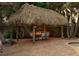 Outdoor dining area featuring a brick-paved patio and a charming tiki hut with seating for six at 102 Crestwood Ln, Largo, FL 33770