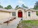 Inviting front entrance with red double doors, beautiful landscaping, and a welcoming walkway at 10423 Sand Lark Ave, Weeki Wachee, FL 34614