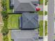 Aerial view of a home with a well-maintained lawn, dark roof, and a paved driveway with a red car at 10814 Whitland Grove Dr, Riverview, FL 33578