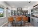 Home bar with a custom wood countertop, display shelving, and seating for guests to relax and enjoy drinks at 10814 Whitland Grove Dr, Riverview, FL 33578