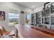 Stylish bar area with custom shelves for displaying liquor, and ample natural light filtering through windows at 10814 Whitland Grove Dr, Riverview, FL 33578
