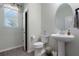 Well-lit bathroom with a pedestal sink, toilet, and window offering natural light at 10814 Whitland Grove Dr, Riverview, FL 33578