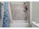 Bathroom with a tub-shower combination tiled with a granite look and a blue patterned shower curtain at 10814 Whitland Grove Dr, Riverview, FL 33578
