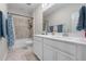 Bright bathroom featuring a double vanity with white cabinets, a tub, and tile flooring at 10814 Whitland Grove Dr, Riverview, FL 33578
