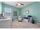 Bedroom with teal walls and an organized desk with shelves, a chair, and neutral carpeting at 10814 Whitland Grove Dr, Riverview, FL 33578