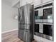 Close-up of stainless refrigerator and double ovens with decorative towel, showcasing kitchen features at 10814 Whitland Grove Dr, Riverview, FL 33578