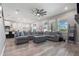 Spacious living room features large windows, a modern ceiling fan, and an oversized sectional sofa at 10814 Whitland Grove Dr, Riverview, FL 33578