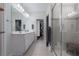 Bright main bathroom with double sinks, a glass-enclosed shower, and a walk-in closet at 10814 Whitland Grove Dr, Riverview, FL 33578