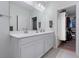 Bathroom with dual sinks, quartz countertops, and a view into the walk-in closet at 10814 Whitland Grove Dr, Riverview, FL 33578