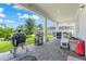Covered patio with grilling area, dining set, and brick pavers extending into the backyard at 10814 Whitland Grove Dr, Riverview, FL 33578