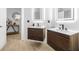 Modern bathroom with dual floating vanities, illuminated mirrors, and sleek wood-look cabinets at 11611 Meridian Point Dr, Tampa, FL 33626