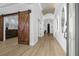 Long hallway with decorative sliding door, vaulted ceiling with cloud mural and modern lit mirrors at 11611 Meridian Point Dr, Tampa, FL 33626