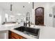 View of kitchen island sink with adjacent wine cellar and open floor plan into living area at 11611 Meridian Point Dr, Tampa, FL 33626