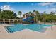 Community pool featuring a water slide, lounge chairs, and tropical landscaping with palm trees at 11611 Meridian Point Dr, Tampa, FL 33626