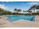 Large community pool with palm trees, lounge chairs, and a serene atmosphere for relaxation and enjoyment at 11611 Meridian Point Dr, Tampa, FL 33626