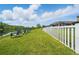 Picturesque backyard featuring lake views, lawn chairs, and a white fence, creating a tranquil outdoor oasis at 11712 Winterset Cove Dr, Riverview, FL 33579