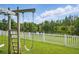 Scenic backyard with a swing set, overlooking a peaceful lake and a lush green landscape at 11712 Winterset Cove Dr, Riverview, FL 33579