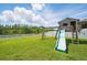 Spacious backyard boasts a playset with a slide, overlooking a tranquil lake and picturesque scenery at 11712 Winterset Cove Dr, Riverview, FL 33579