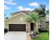 Charming two-story home featuring a two-car garage, stone accents, and lush landscaping at 11712 Winterset Cove Dr, Riverview, FL 33579