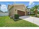 Side view of a well-maintained home featuring a two-car garage and green lawn at 11712 Winterset Cove Dr, Riverview, FL 33579
